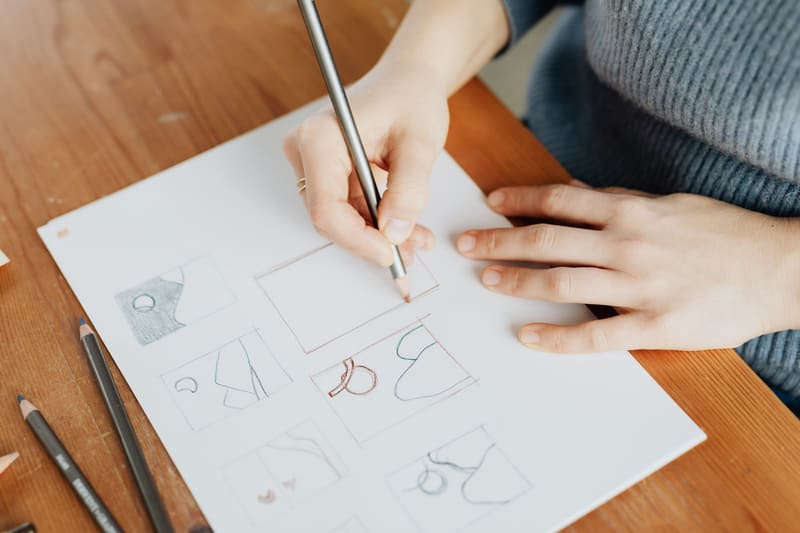 Diseñadora dibujando bocetos del nuevo logotipo durante un proceso de rebranding