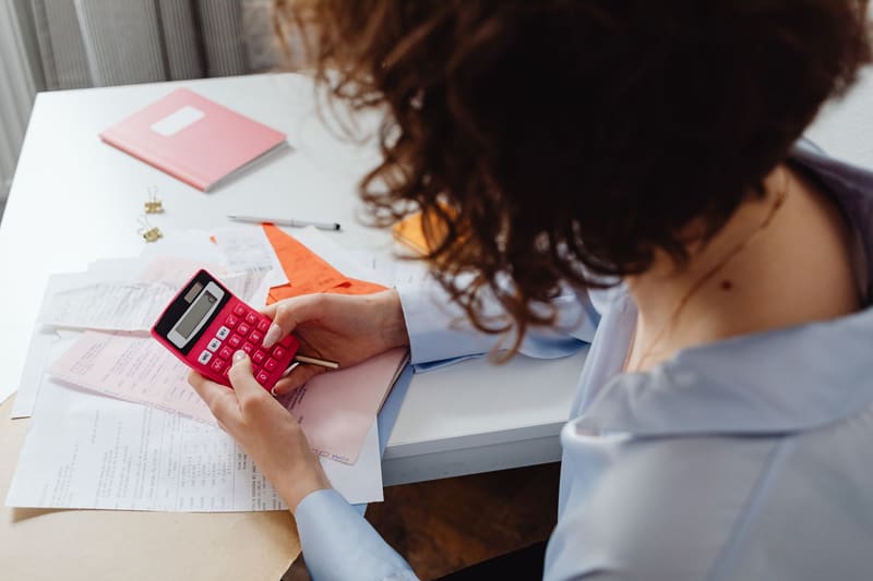 Dueña de un negocio calculando con facturas el precio del SEO antes de contratarlo