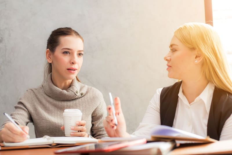 Dueña de un negocio preguntando a una consultora SEO freelance en la primera reunión