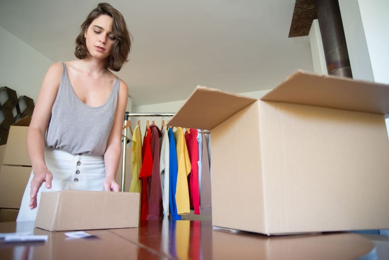 Dueña de una tienda de ropa prepara cajas de pedidos tras crear su tienda online