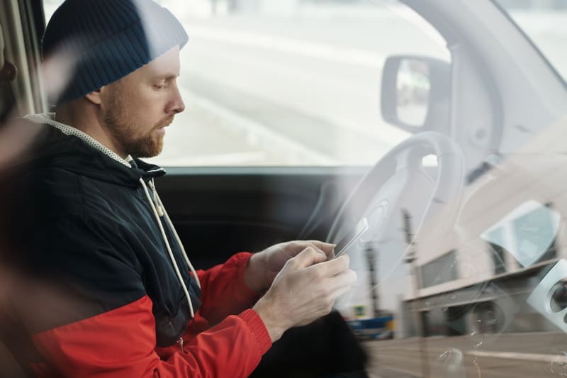 Conductor buscando un taller en el móvil desde su coche, la primera etapa del embudo de ventas de un negocio local