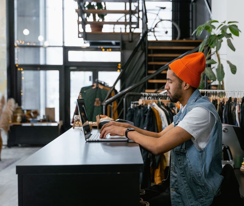 Dueño de una tienda revisa en el portátil el mantenimiento web de su negocio