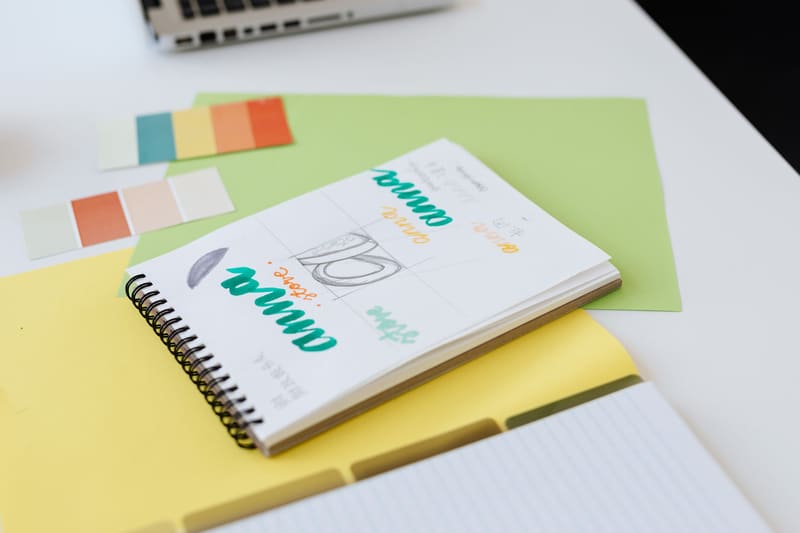 Cuaderno con bocetos del logotipo y muestras de color para preparar un manual de marca