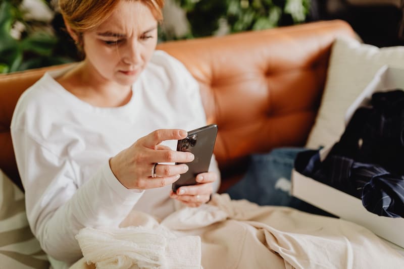 Clienta mirando Instagram en el móvil desde el sofá de casa, el momento en que conviene publicar