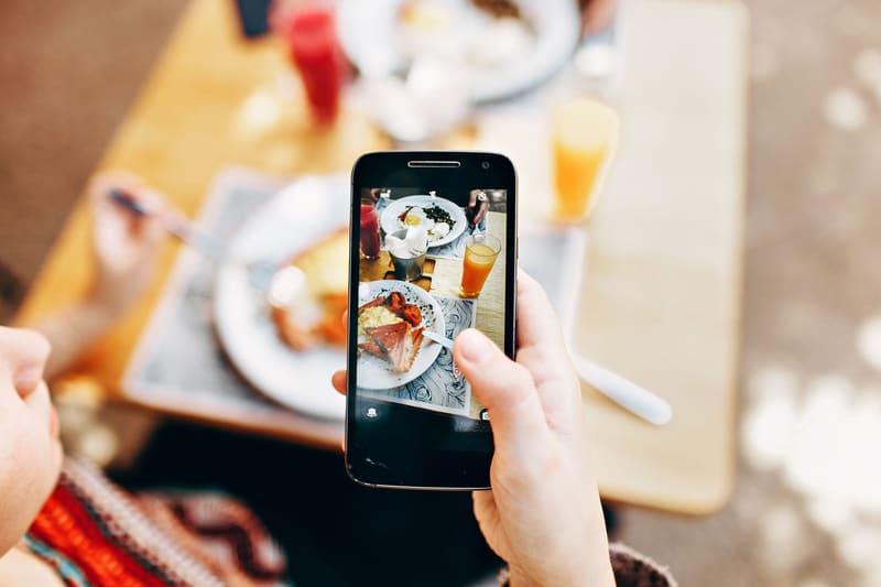 Móvil haciendo la foto de un desayuno en una cafetería para publicarla en Instagram a la mejor hora