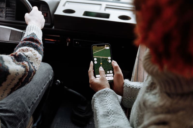 Pasajera buscando un negocio en Google Maps con el móvil dentro del coche